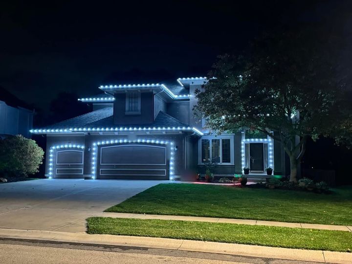 A two-story home in cool white C9 bulbs along the rooflines and around both garage doors and the front door